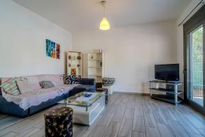 a living room with a couch and a tv at Cretan Blue Bungalow Chania in Chania