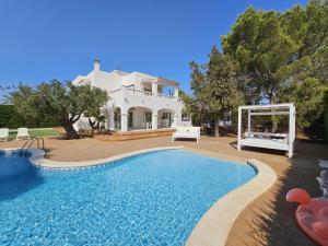 a villa with a swimming pool in front of a house at INIBIZA VILLAS - Villa Oasis in Sant Jordi