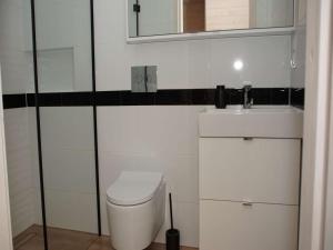 une salle de bains blanche avec toilettes et lavabo dans l'établissement Beautiful holiday home, 2 bedrooms, Mielenko, à Mielenko