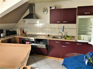 una cucina con armadi marroni, lavandino e piano cottura di Ferienwohnung in Lauterbach im Schwarzwald a Lauterbach