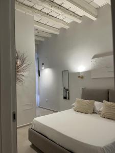 Un dormitorio con una gran cama blanca en una habitación. en Almarì, en Cagliari