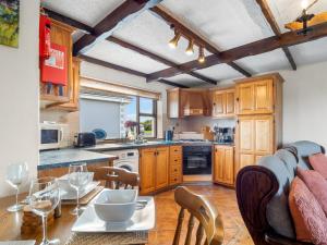 a kitchen with wooden cabinets and a table with chairs at Tigh An Bheachaire in Carraroe