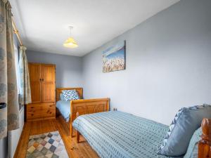 a bedroom with two twin beds and a cabinet at Tigh An Bheachaire in Carraroe