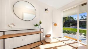 Casa del Sol Heated Pool & Spa في سورينتو: غرفة بيضاء مع مرآة ونافذة