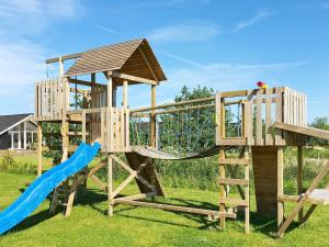 a wooden playset with a slide and a slideintend at Luxury Pool Villa by Sea - By Traum Ferienwohnungen in Marielyst