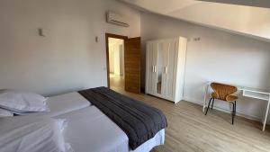 a bedroom with a large white bed and a chair at Apartamentos Boutique Don Miguel in Noja +12 photos