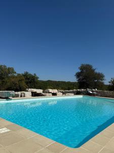 a large blue swimming pool with a blue sky in the background at Mas de Méjas Chambre d'hôtes La Pierraille in Calvignac