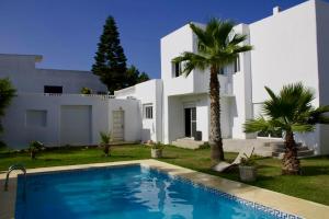 a villa with a swimming pool in front of a house at Spacious villa, sea view in Cabo Negro