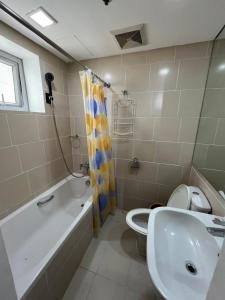 a bathroom with a tub and a sink and a toilet at Antel Spa Residences 9A in Manila