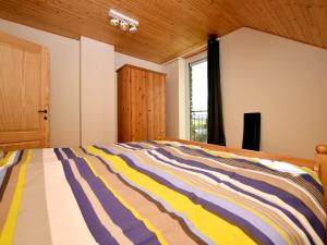 a bedroom with a bed with a colorful striped comforter at Cosy Holiday Home in Durbuy with Garden in Durbuy +26 photos