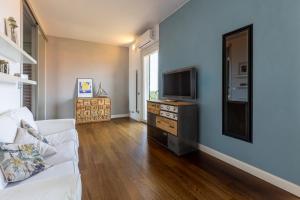 Una sala de estar con un sofá blanco y un televisor. en Lamar Residenza al Mare di Tellaro, en Lerici