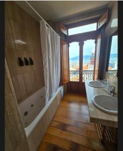 a bathroom with a sink and a shower with a window at Casa Mama in Vigo +25 photos
