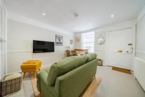 a living room with a green couch and a television at 136 Southgate St, Bury St Edmunds in Bury Saint Edmunds