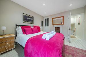 a bedroom with a large bed with pink pillows at 136 Southgate St, Bury St Edmunds in Bury Saint Edmunds