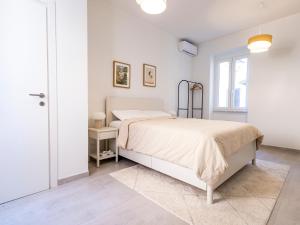a white bedroom with a bed and a window at Suite Apartment Albano Laziale in Albano Laziale