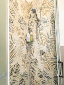 a shower in a bathroom with a tropical wallpaper at Suite Apartment Albano Laziale in Albano Laziale +24 photos