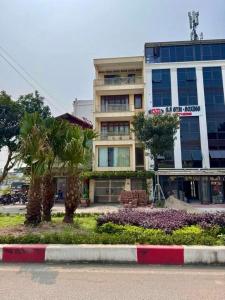 Un gran edificio con palmeras delante. en An Home, en Ninh Binh