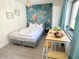ein Schlafzimmer mit einem Bett und einem Tisch mit einer Obstschale in der Unterkunft Cozy Studioapartment in Würzburg