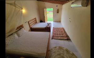 BraffédonにあるBamboo Tree House Hotelのベッド2台と窓のある寝室 +7枚の写真