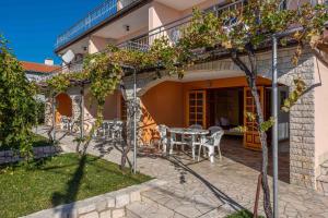 a patio of a house with a table and chairs at Apartments in Crikvenica 43070 in Barci