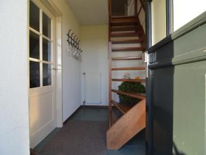 a hallway with a staircase and a black refrigerator at Farmhouse in Elsendorp near Forest Trails in Elsendorp