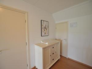 a white room with a cabinet and a door at Farmhouse in Elsendorp near Forest Trails in Elsendorp