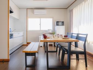 a kitchen with a table and chairs and a kitchen with a refrigerator at Shishimai Kushiro in Kushiro
