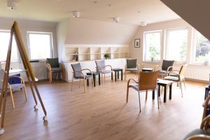 an empty waiting room with chairs and tables and windows at Luchs Quartier Hahnenklee in Hahnenklee-Bockswiese