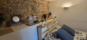 a bedroom with a bed and a stone wall at Chambre cocoon in Roquemaure