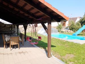a pavilion with a swing and a playground at Apartmán Vrbno in Kadov