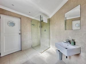 a bathroom with a glass shower and a sink at Harbor View Cottage in Hout Bay +12 photos