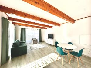 a living room with a table and chairs and a couch at Harbor View Cottage in Hout Bay