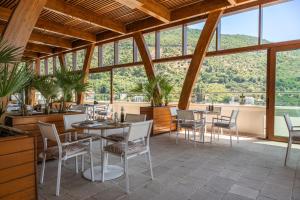 a restaurant with tables and chairs and large windows at Iberostar Waves Slavija in Budva
