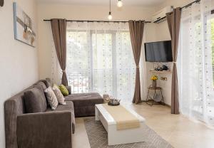 a living room with a couch and a tv at Stylish Flat with Free Pool Access, Bendita Mare by Flat Mаnаger in Varna City