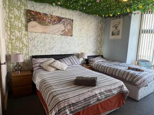 two beds in a bedroom with lights on the ceiling at The Pembroke in Blackpool