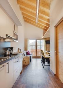 eine Küche mit weißen Schränken und einer Holzdecke in der Unterkunft Apartments Oberpichlhof in Olang
