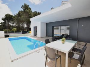 a dining area with a table and a swimming pool at Sunny Villa Near Óbidos w Beaches in Nadadouro