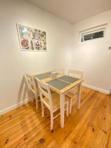 a dining room table with chairs and a painting on the wall at 3 Bedroom Terraced House with Free Parkings, Close to City Centre and Transportation Links, at Gateshead, Newcastle upon Tyne in Gateshead +4 photos