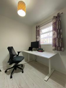 an office with a desk and a chair and a window at 3 Bedroom Terraced House with Free Parkings, Close to City Centre and Transportation Links, at Gateshead, Newcastle upon Tyne in Gateshead