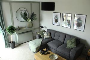 a living room with a gray couch and a table at Riverside Haven in Ardara in Ardara