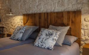 a bedroom with a bed with a wooden headboard and pillows at Casa Vieja de la Abuela in Fuentesaúco de Fuentidueña