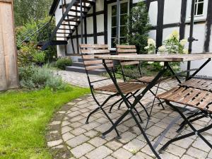 un tavolo da picnic e due sedie davanti a una casa di Weingut Bindges - Apartment Rosenhof a Traben-Trarbach Altre 2 foto