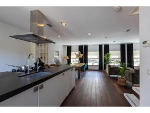 a kitchen with a counter top and a living room at Central Domburg Apartment in Domburg