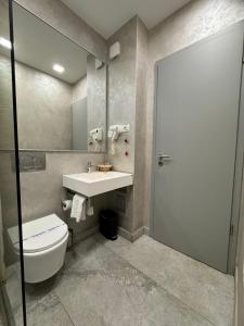 a bathroom with a toilet and a sink at Hotel Prestige in Mamaia
