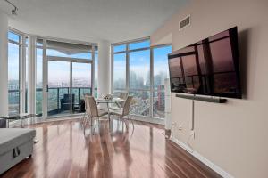 a living room with a table and chairs and windows at Downtown Condo with Picturesque View in Toronto