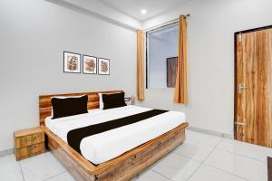 a bedroom with a large bed and a window at Super Collection O Iskcon Temple Mansarovar Formerly Chinar Inn in Jaipur