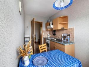 a small kitchen with a table with a blue table cloth at idyllische Ferienwohnung in Lichtenhain in Lichtenhain