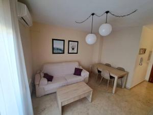 a living room with a white couch and a table at Universidad 2 by Southern Rooms in Jaén