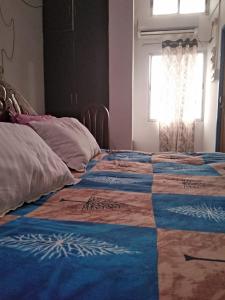 a bed with a quilt on it in a room at Globalindia Homestay in Guwahati +4 photos