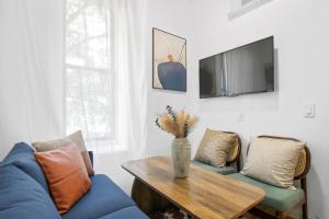 a living room with a blue couch and a table at Upscale 2BR Home in New York